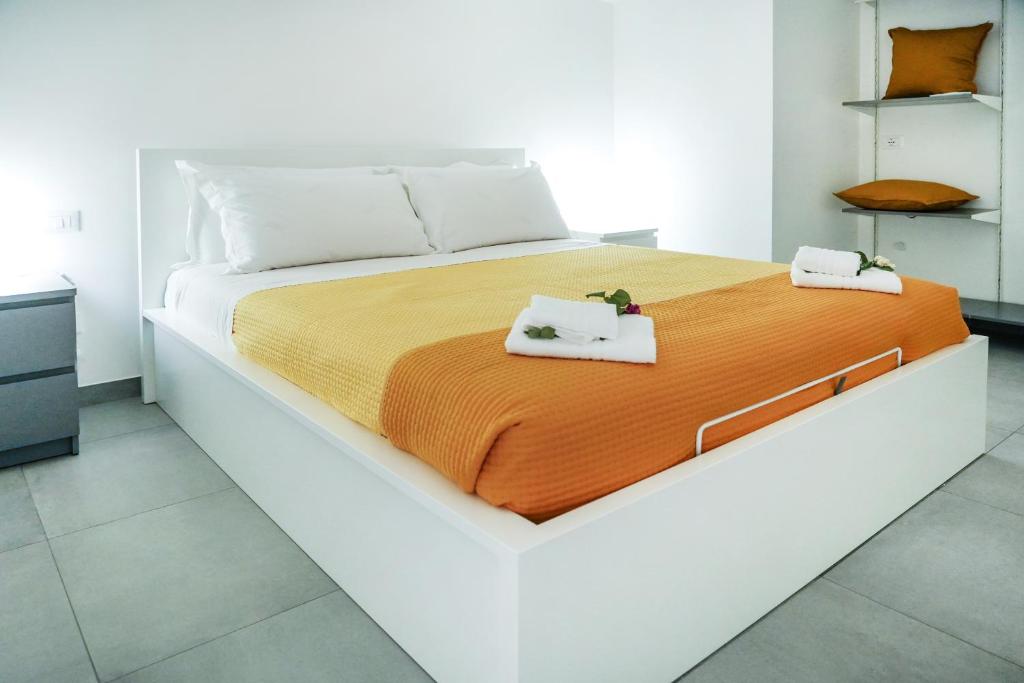 - une chambre blanche avec un grand lit recouvert d'une couverture orange dans l'établissement Luxury Villa La Perla - Castellammare del golfo with Pool, Garden and Parking, à Castellammare del Golfo 35 autres photos