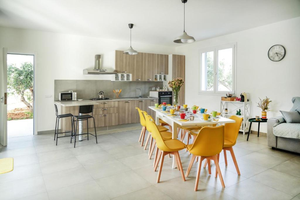 une cuisine et une salle à manger avec une table et des chaises jaunes dans l'établissement Luxury Villa La Perla - Castellammare del golfo with Pool, Garden and Parking, à Castellammare del Golfo