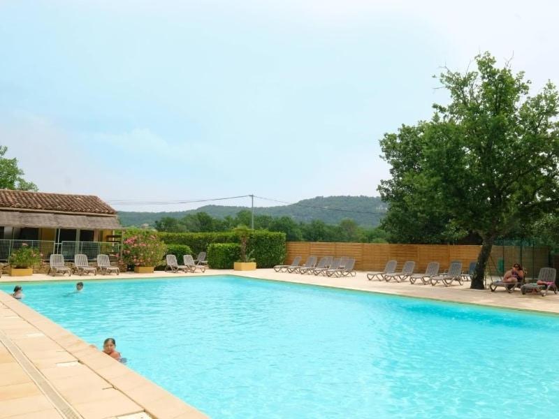 une grande piscine bleue avec des gens dedans dans l'établissement Camping maeva Escapades Le Domaine des Chênes Blancs, à Croagnes
