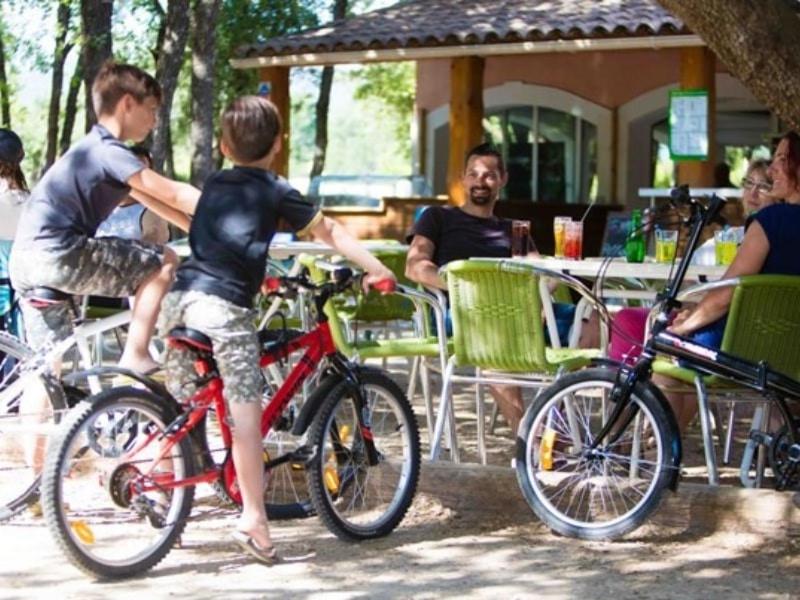 deux jeunes garçons sur leurs vélos dans un restaurant dans l'établissement Camping maeva Escapades Le Domaine des Chênes Blancs, à Croagnes