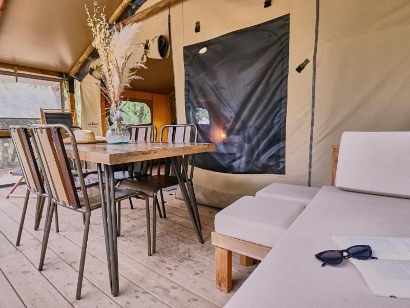 une salle à manger avec une table et des chaises dans une tente dans l'établissement Camping maeva Escapades Le Domaine des Chênes Blancs, à Croagnes