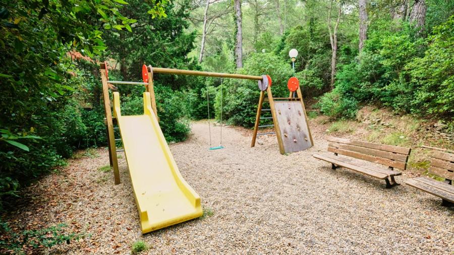 - une aire de jeux avec toboggan et banc dans l'établissement Camping maeva Respire La Vallée Heureuse, à Orgon