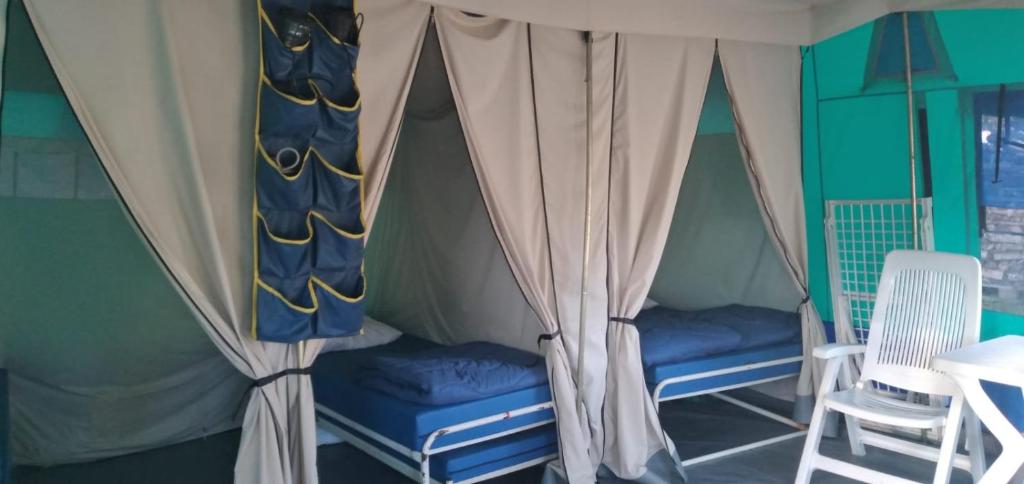 une chambre avec deux chaises et une tente dans l'établissement Camping maeva Respire La Vallée Heureuse, à Orgon