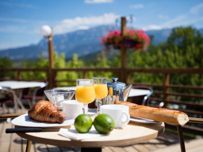 une table avec de la nourriture et des verres de jus d'orange dans l'établissement Camping maeva Escapades Le Couriou, à Recoubeau-Jansac 31 autres photos