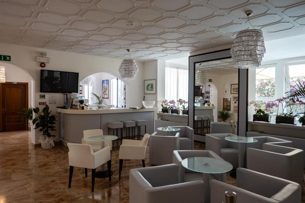 un restaurant avec des tables, des chaises et un comptoir dans l'établissement Grande Albergo Marin, à Lignano Sabbiadoro
