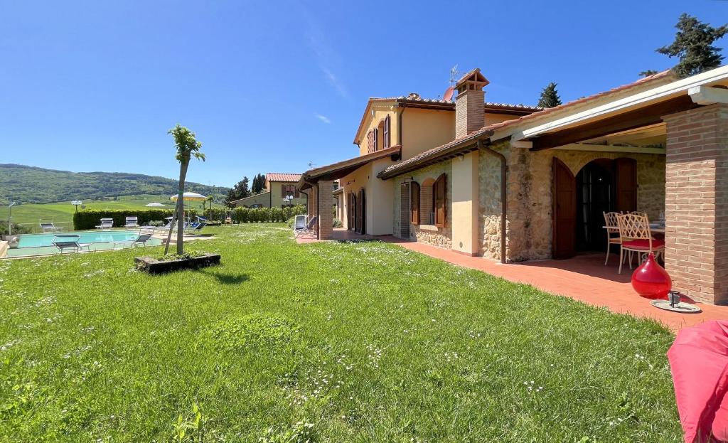 une maison avec une cour à côté d'une piscine dans l'établissement Panoramic Villa Ludovica with private pool - Borgo del Silenzio, à Orciatico