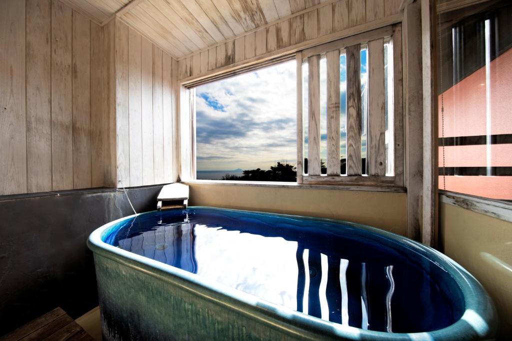 - une grande baignoire bleue dans une chambre avec fenêtre dans l'établissement 伊豆高原の隠れ宿Syuhari守破離, à Itō 25 autres photos