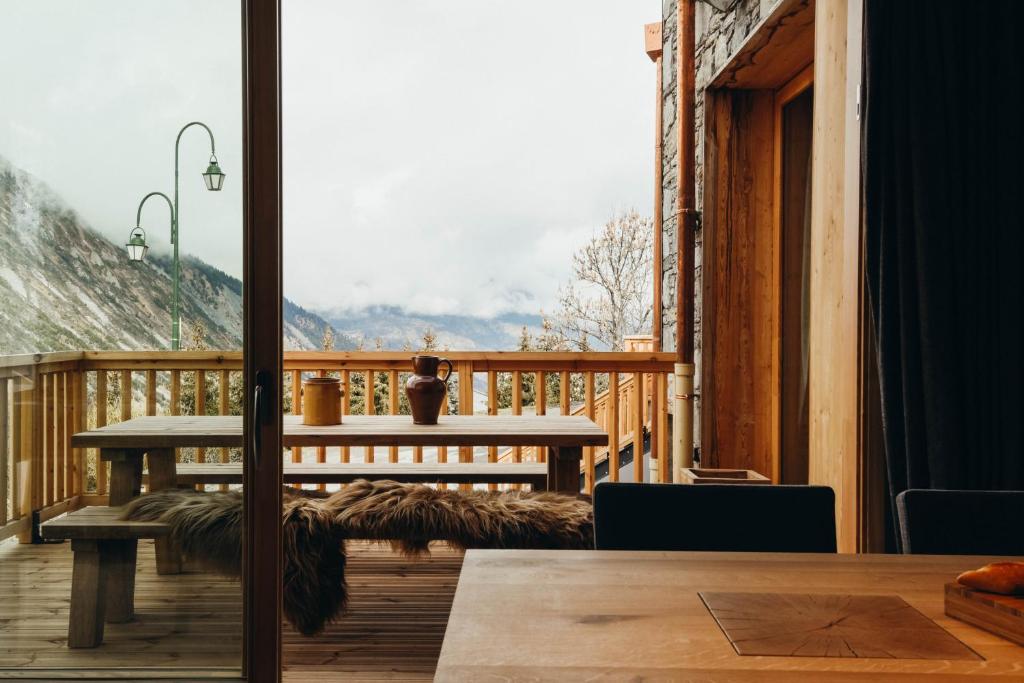 d'un balcon avec une table et une vue sur les montagnes. dans l'établissement Charmaix by Lodji, à Saint-Martin-de-Belleville 14 autres photos