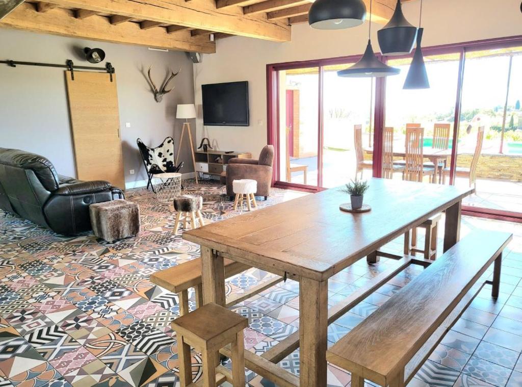 un salon avec une table et des chaises en bois dans l'établissement La ROSÉE des Cévennes Gîte 120m2 à 5min d'Anduze, à Massillargues-Attuech