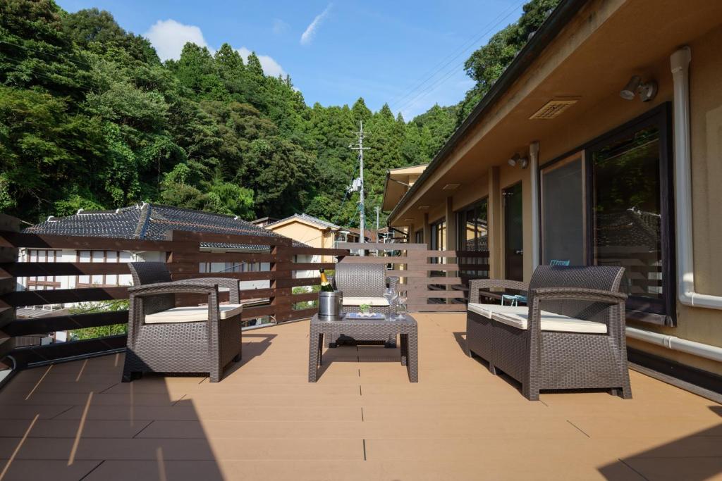 d'une terrasse avec des chaises et des tables sur un balcon. dans l'établissement Arifuku Onsen Yoshidaya, à Gotsu