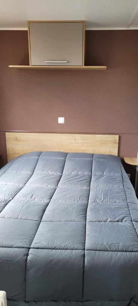 Ce lit se trouve dans une chambre dotée d'une couverture bleue. dans l'établissement Évolution, à Fréjus