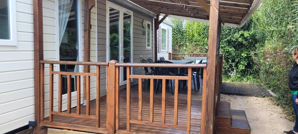 une terrasse en bois avec une table et des chaises sur une maison dans l'établissement Évolution, à Fréjus