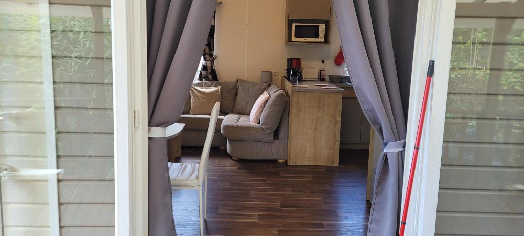 une vue d'un salon avec un canapé et des rideaux dans l'établissement Évolution, à Fréjus