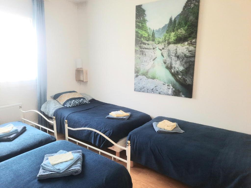 - 3 lits dans une chambre avec un tableau mural dans l'établissement GITE CHEZ MONETTE, à Nance 37 autres photos