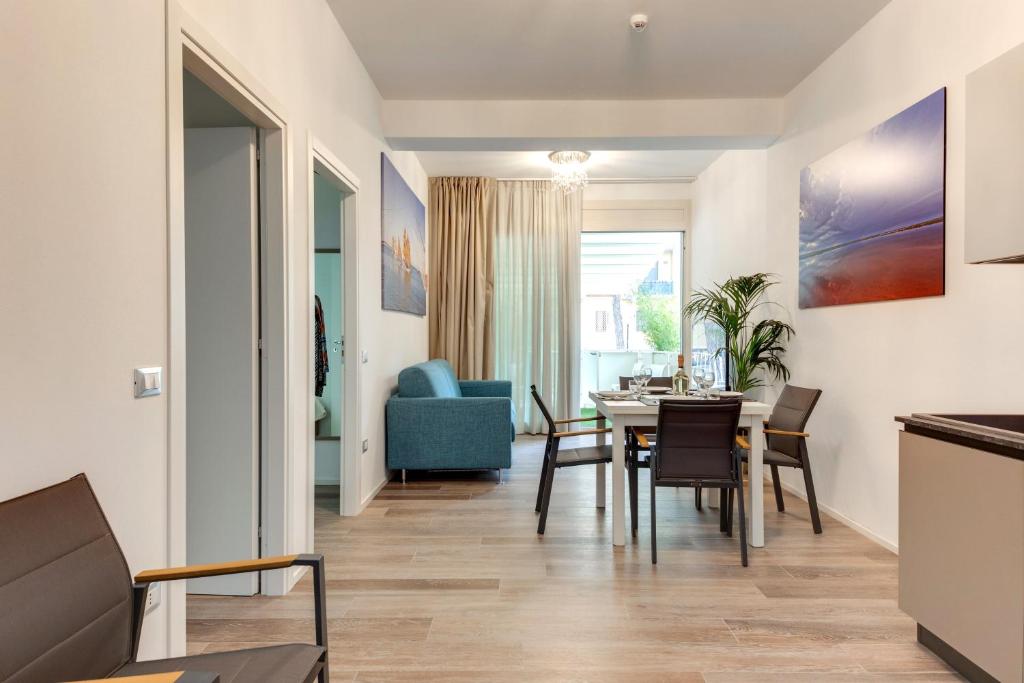 une salle à manger et un salon avec une table et des chaises dans l'établissement Elegance Suite Apartments - Siroli Collection, à Cervia