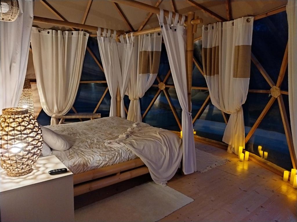 Ce lit se trouve dans un dortoir doté de rideaux blancs. dans l'établissement Le Clos FMR Insolite Manon Carcassonne, à Malves