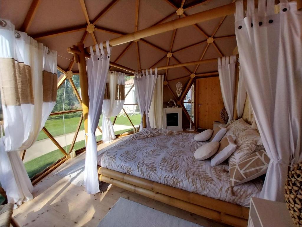 une chambre avec un lit dans une tente dans l'établissement Le Clos FMR Insolite Manon Carcassonne, à Malves