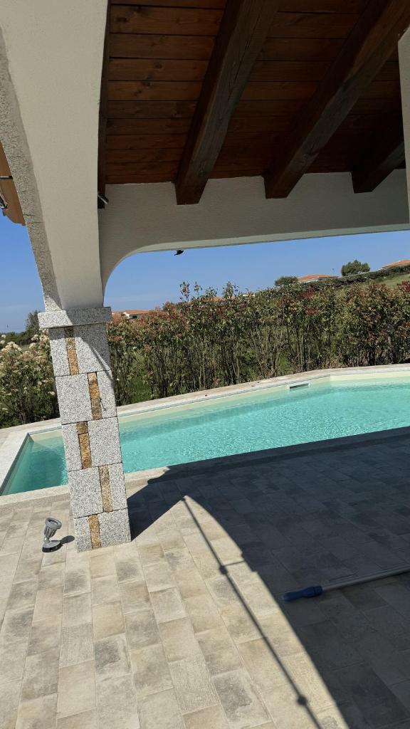 une maison avec piscine avec un toit dans l'établissement Oasi del relax, à Budoni