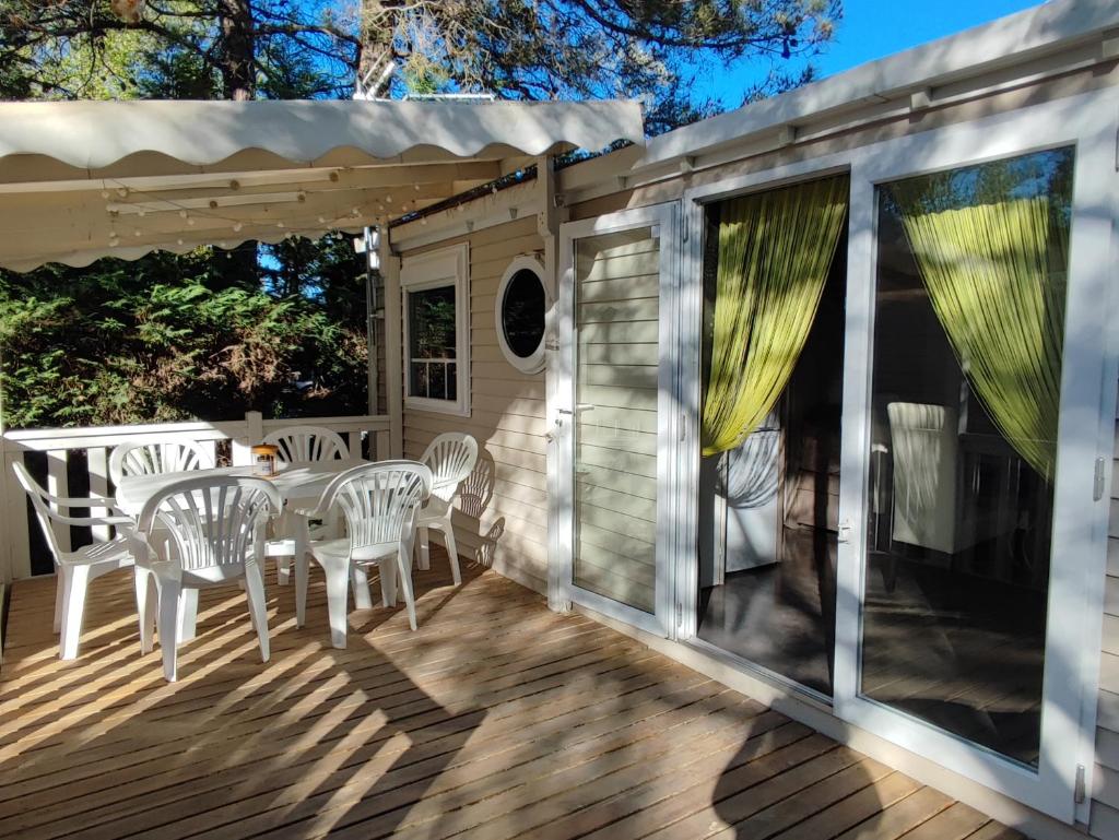 une terrasse avec une table et des chaises. dans l'établissement Céline et Alain, mobil Home cosy, à La Roque-dʼAnthéron