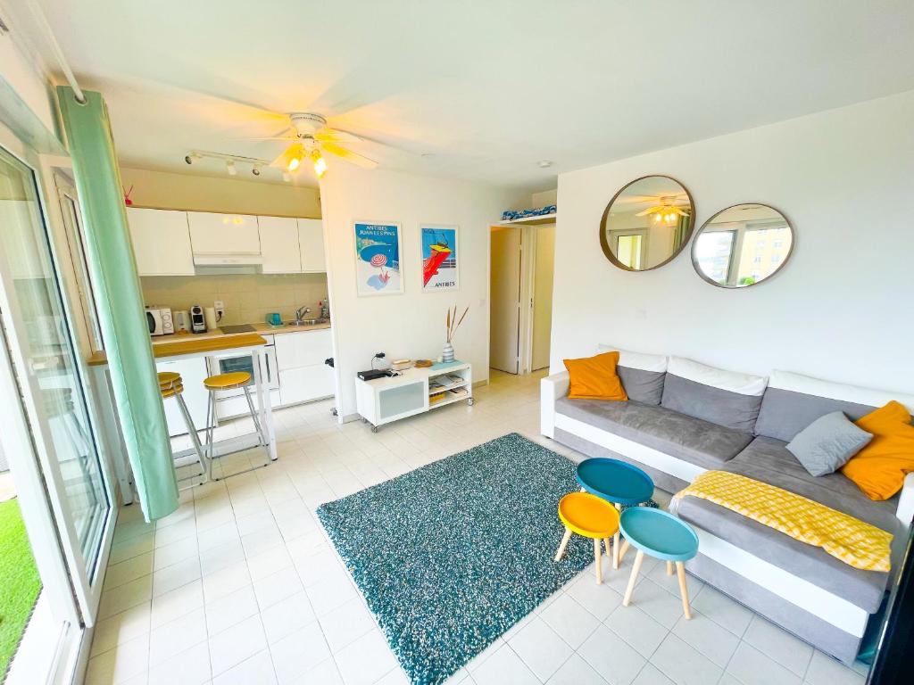 un salon avec un canapé et une cuisine dans l'établissement 1 bedroom Sea view, swimming pool, beach on foot, parking, à Antibes
