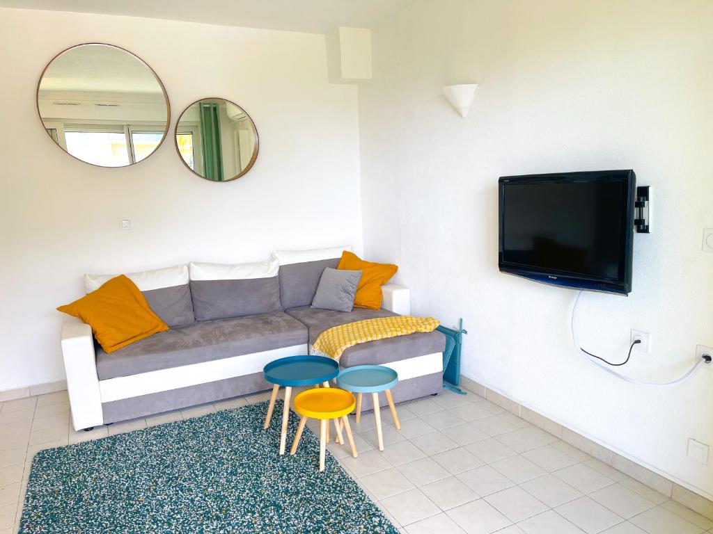 - un salon avec un canapé, 2 tables et une télévision dans l'établissement 1 bedroom Sea view, swimming pool, beach on foot, parking, à Antibes