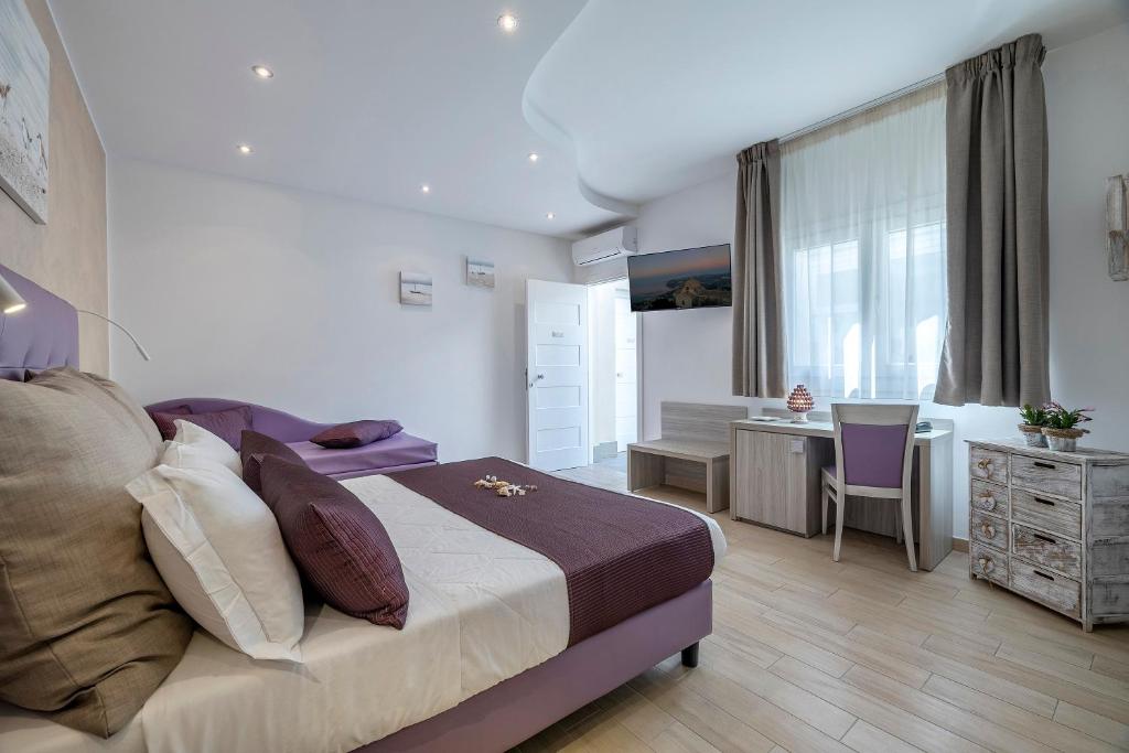 une chambre d'hôtel avec un lit et un bureau et un bureau dans l'établissement Hotel Soffio D'Estate, à San Vito Lo Capo