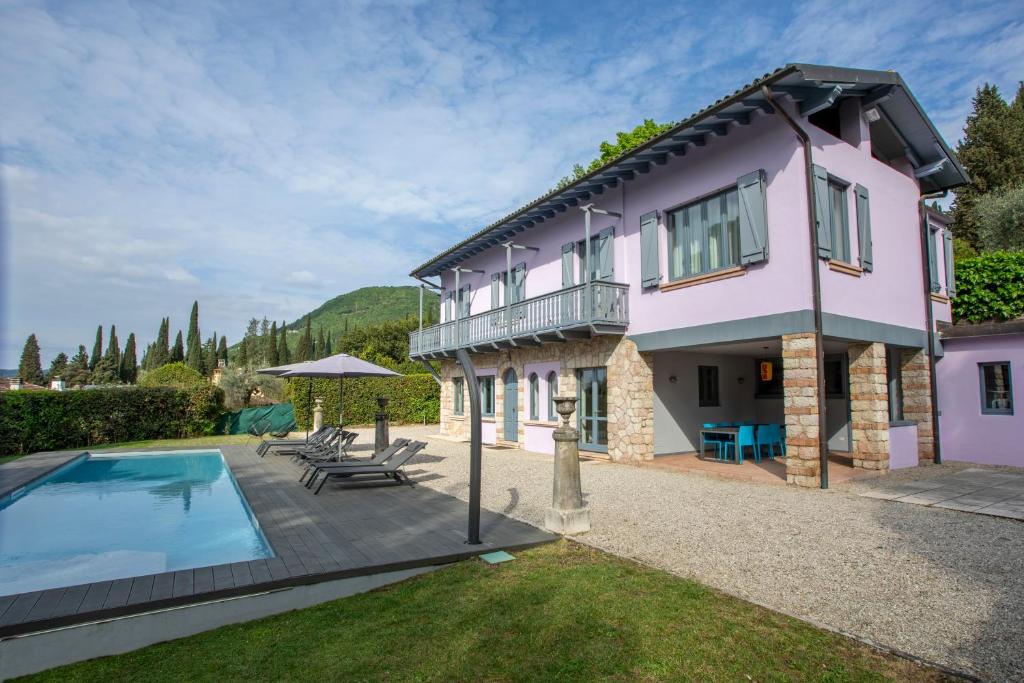 une maison avec une piscine dans la cour dans l'établissement Villa Laura, à Gardone Riviera