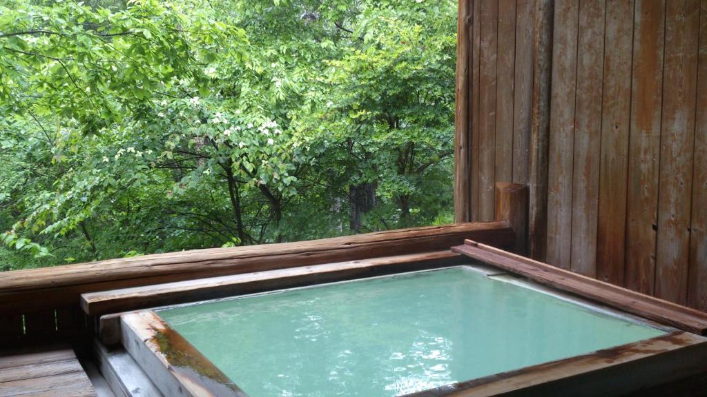 un bain à remous sur une terrasse couverte avec une fenêtre dans l'établissement ピーポロ乗鞍, à Matsumoto 95 autres photos
