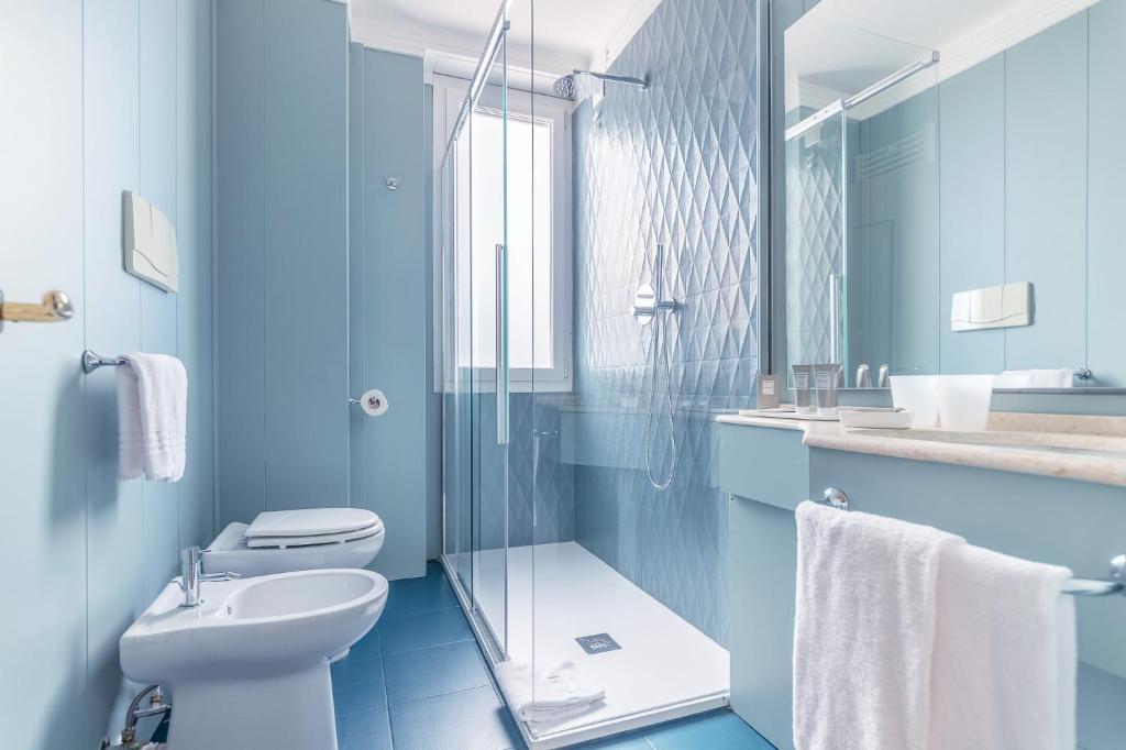 une salle de bain bleue avec des toilettes et un lavabo dans l'établissement Diana Grand Hotel, à Alassio