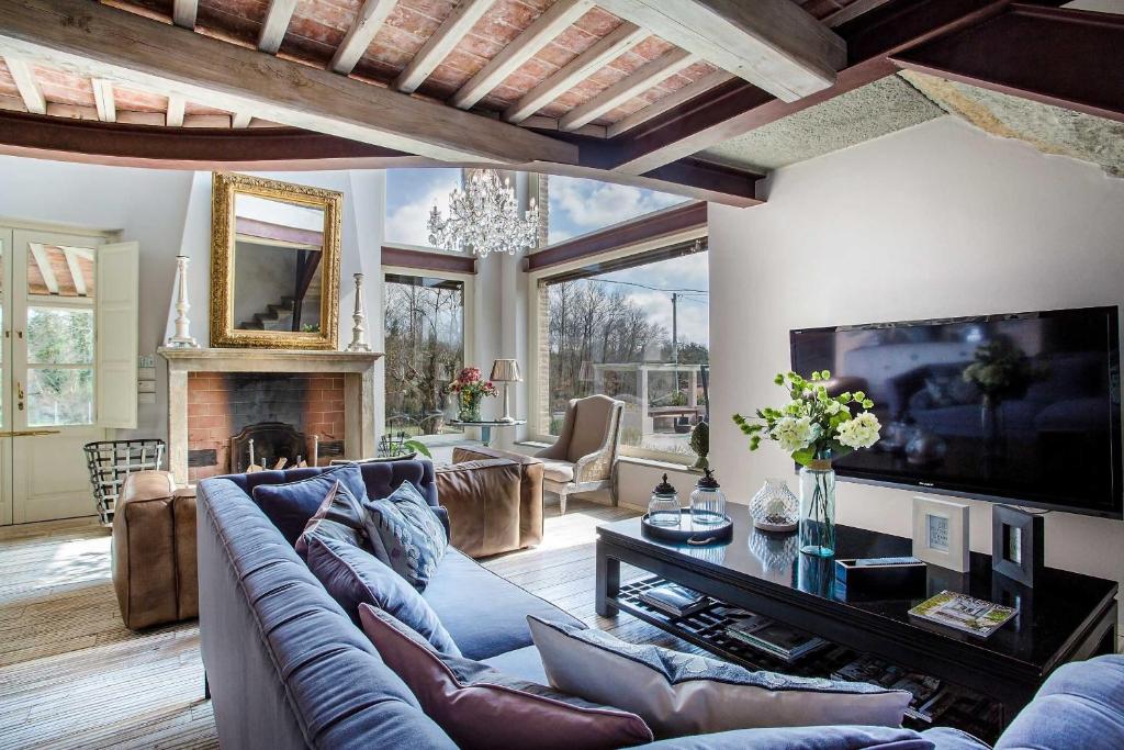 un salon avec un canapé et une télévision dans l'établissement Villa Otto Luxury Tuscan Farmhouse with Pool, à Orentano