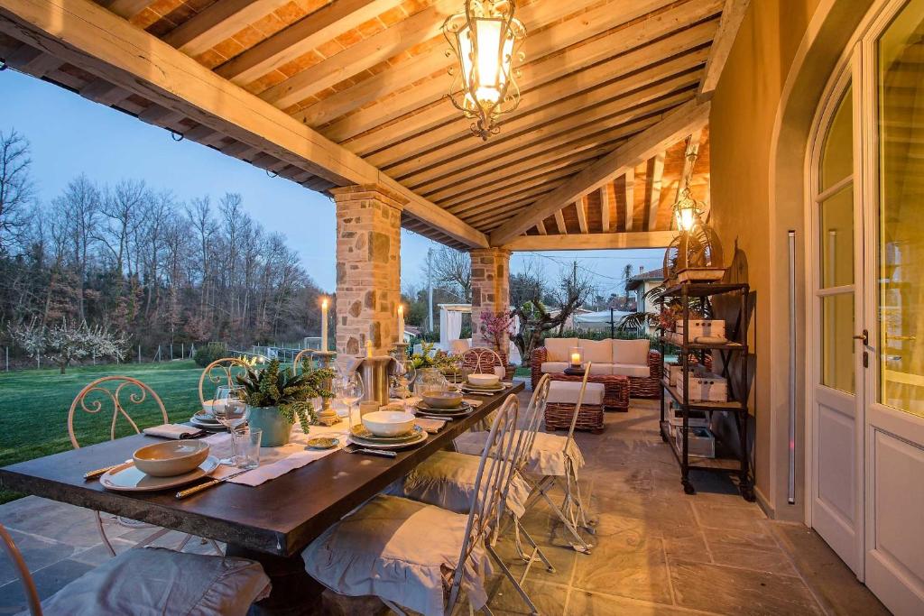 une salle à manger extérieure avec une table et des chaises dans l'établissement Villa Otto Luxury Tuscan Farmhouse with Pool, à Orentano
