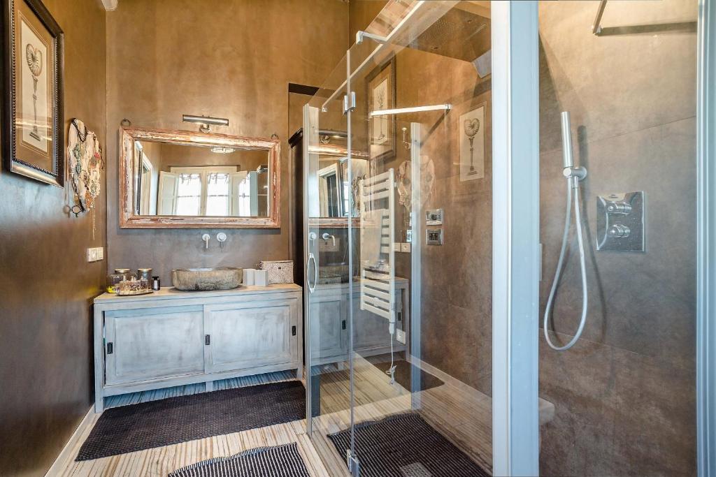 une salle de bain avec une douche, un lavabo et un miroir dans l'établissement Villa Otto Luxury Tuscan Farmhouse with Pool, à Orentano