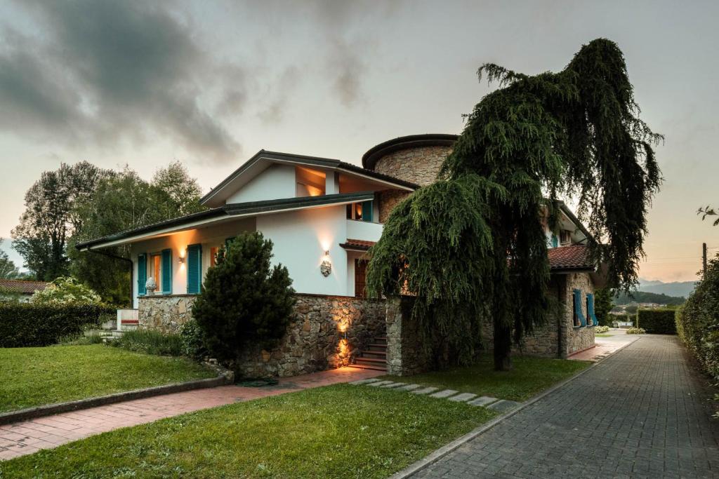 une maison avec un arbre devant dans l'établissement Villa Annalisa, à Lucques
