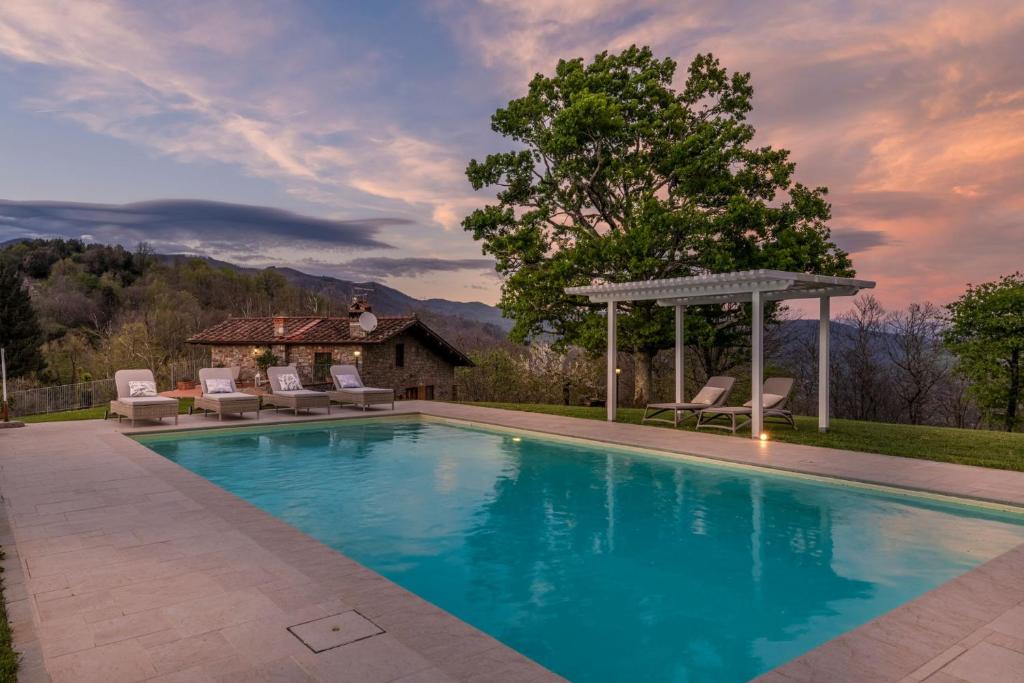 une piscine avec des chaises et un gazebo dans l'établissement Grumo Farmhouse with Private Pool and View near Lucca, à Lucques