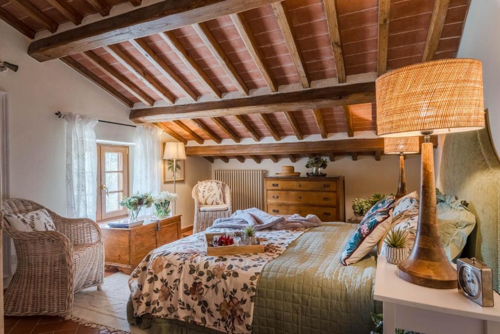 une chambre avec un lit et un plafond en bois dans l'établissement Grumo Farmhouse with Private Pool and View near Lucca, à Lucques