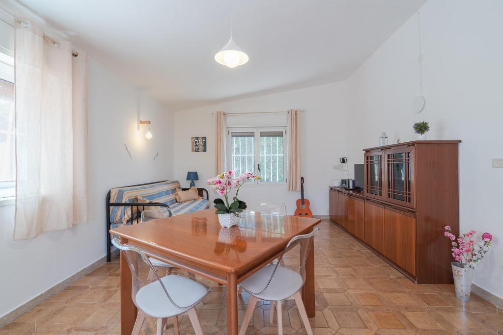 un salon avec une table et des chaises en bois dans l'établissement Villa Nonna Anna a Plemmirio, à Syracuse