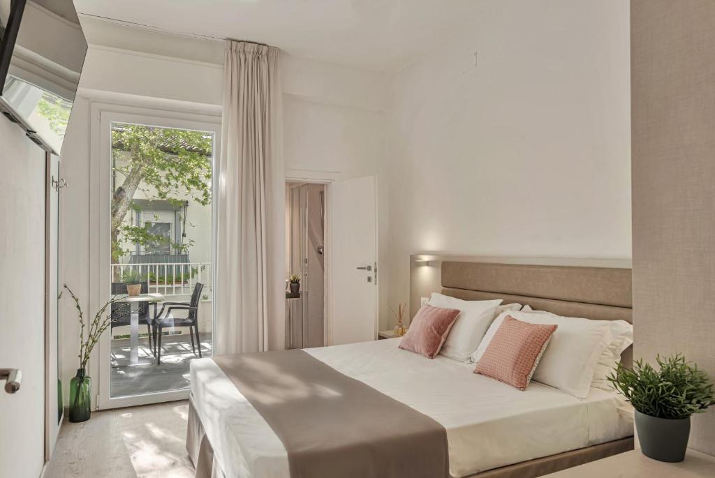 une chambre avec un grand lit et un balcon dans l'établissement Hotel Lux, à Gabicce Mare