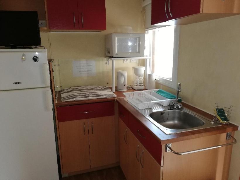 une petite cuisine avec un évier et un réfrigérateur dans l'établissement CAMPING 3* / GORGES DU VERDON / POUR 2 PERS/ LAVANDE / ACTIVITÉS/A 2 MN DU LAC DE STE CROIXI, à Sainte-Croix-de-Verdon 7 autres photos