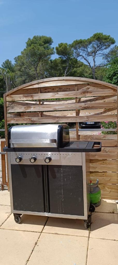 un barbecue assis devant une clôture en bois dans l'établissement Havre de paix pour 2 à 4 pers., au Castellet