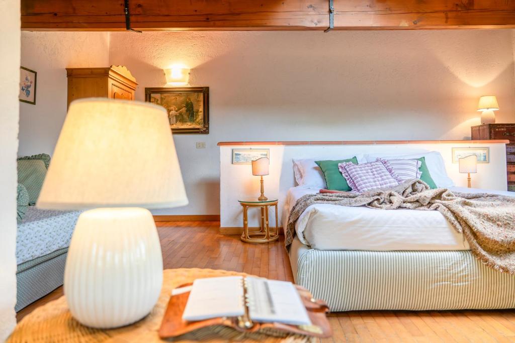 une chambre avec un lit et une table avec une lampe dans l'établissement Casale le Muracce, à L'Ugolino