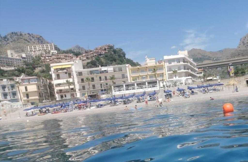 - une vue sur une plage avec des bâtiments dans l'établissement Hotel Orizzonte, à Letojanni