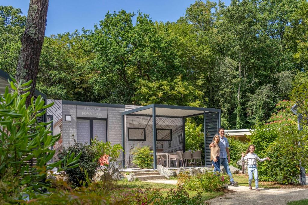 une famille debout devant une petite maison dans l'établissement Nantes Camping Le Petit Port, à Nantes