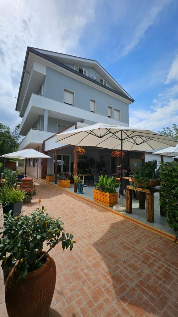 un bâtiment avec des tables et des parasols devant lui dans l'établissement Hotel Cerrano, à Silvi Marina