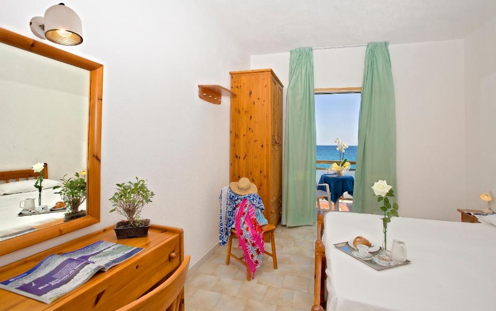 une chambre avec un lit, un miroir et une fenêtre dans l'établissement Hotel Vittorio Beach Resort, à Ischia