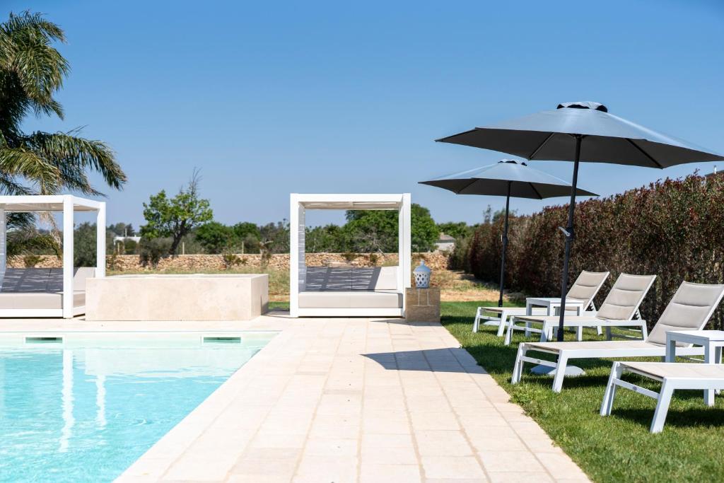 - un groupe de chaises et un parasol à côté de la piscine dans l'établissement Villa Lucia - Exclusive Private Pool, à Gallipoli