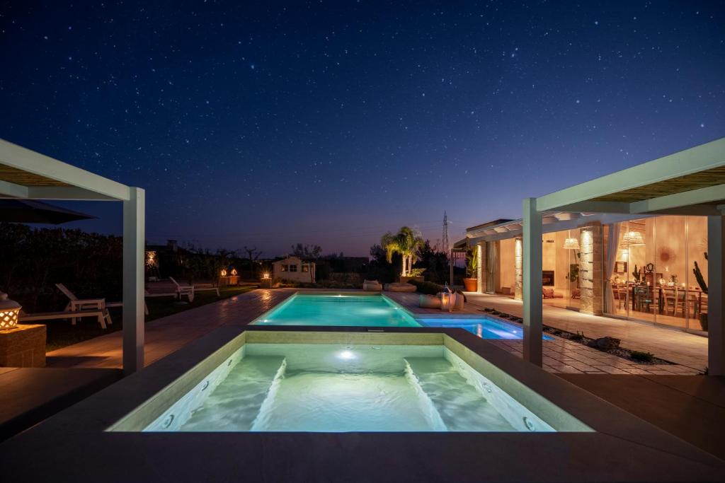une piscine au milieu d'une maison la nuit dans l'établissement Villa Lucia - Exclusive Private Pool, à Gallipoli