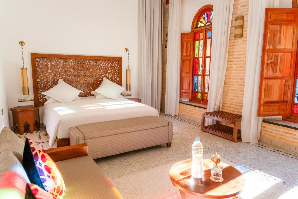 une chambre avec un lit et une table dans une pièce dans l'établissement Riad Al Ansari, à Fès