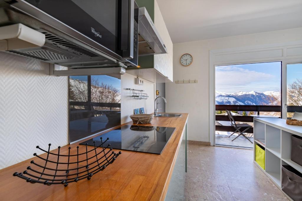 - une cuisine avec un comptoir offrant une vue sur les montagnes dans l'établissement Lou Moussu, à Gourette