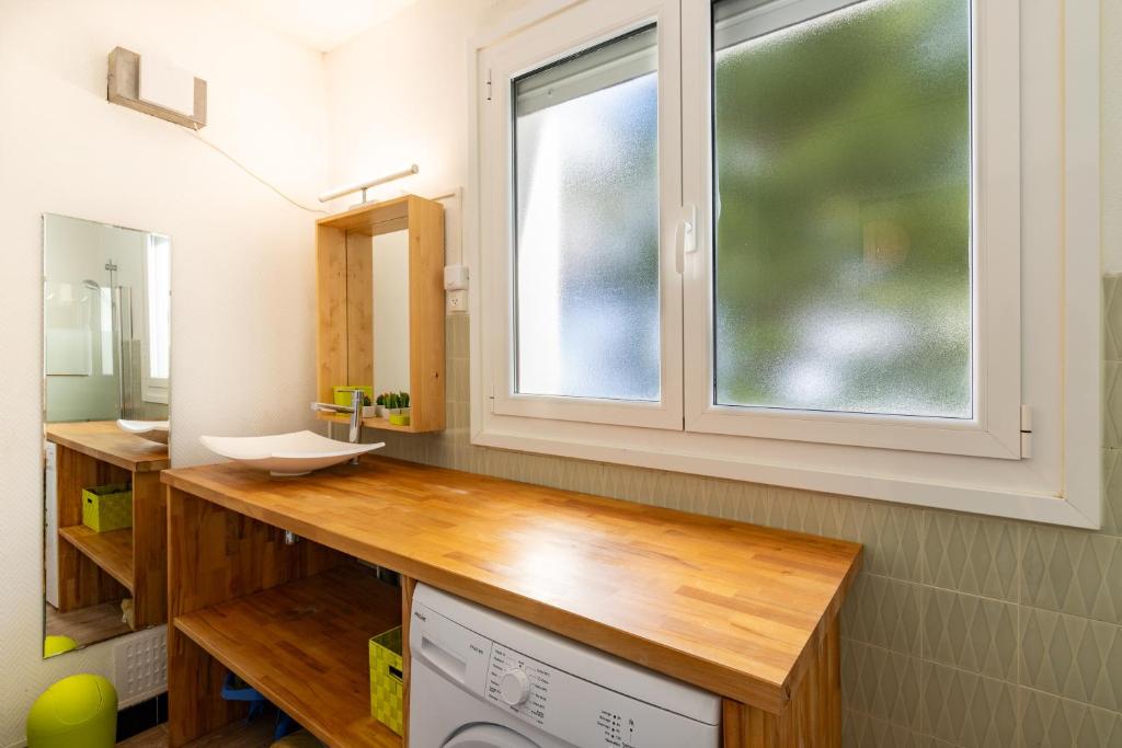 une salle de bain avec un lavabo et une fenêtre dans l'établissement Lou Moussu, à Gourette