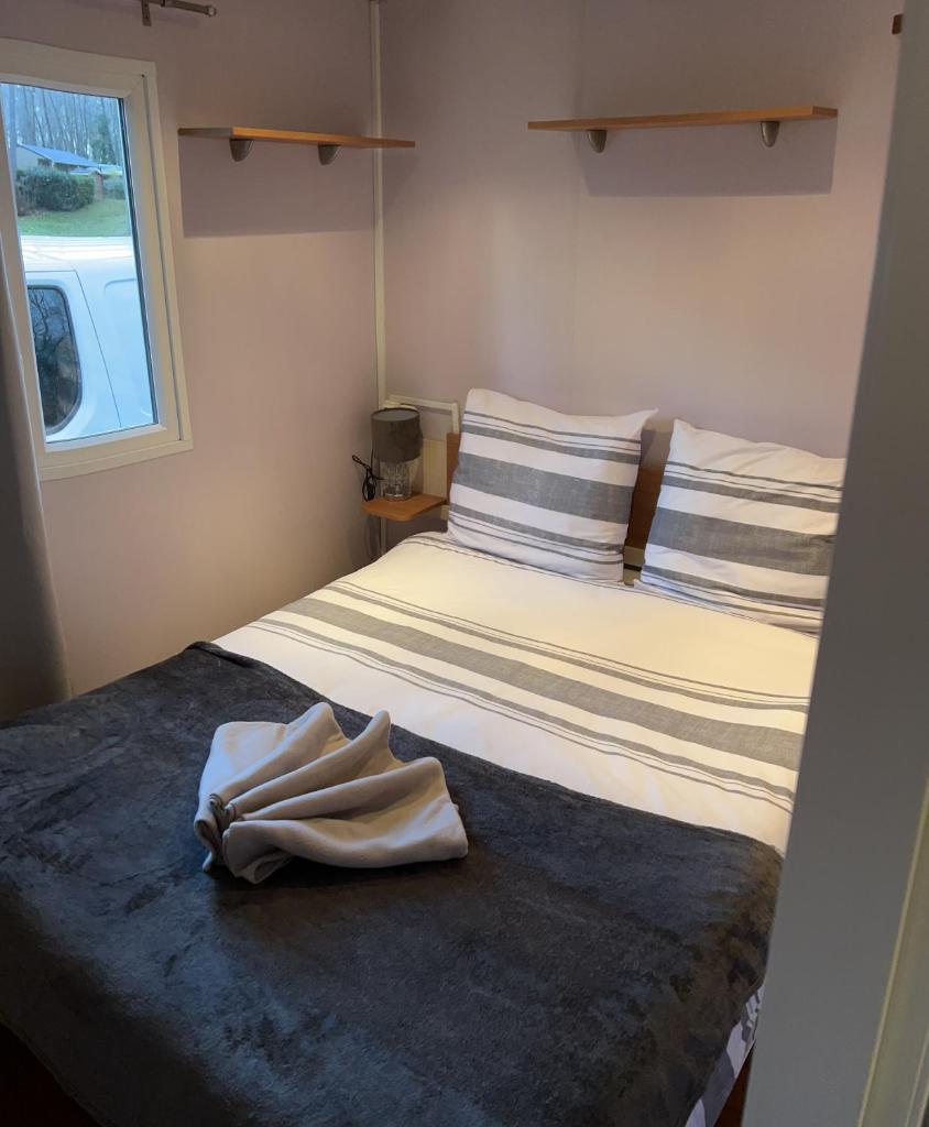une chambre avec un lit avec une serviette dessus dans l'établissement mobil home, à Mirgaudon 18 autres photos